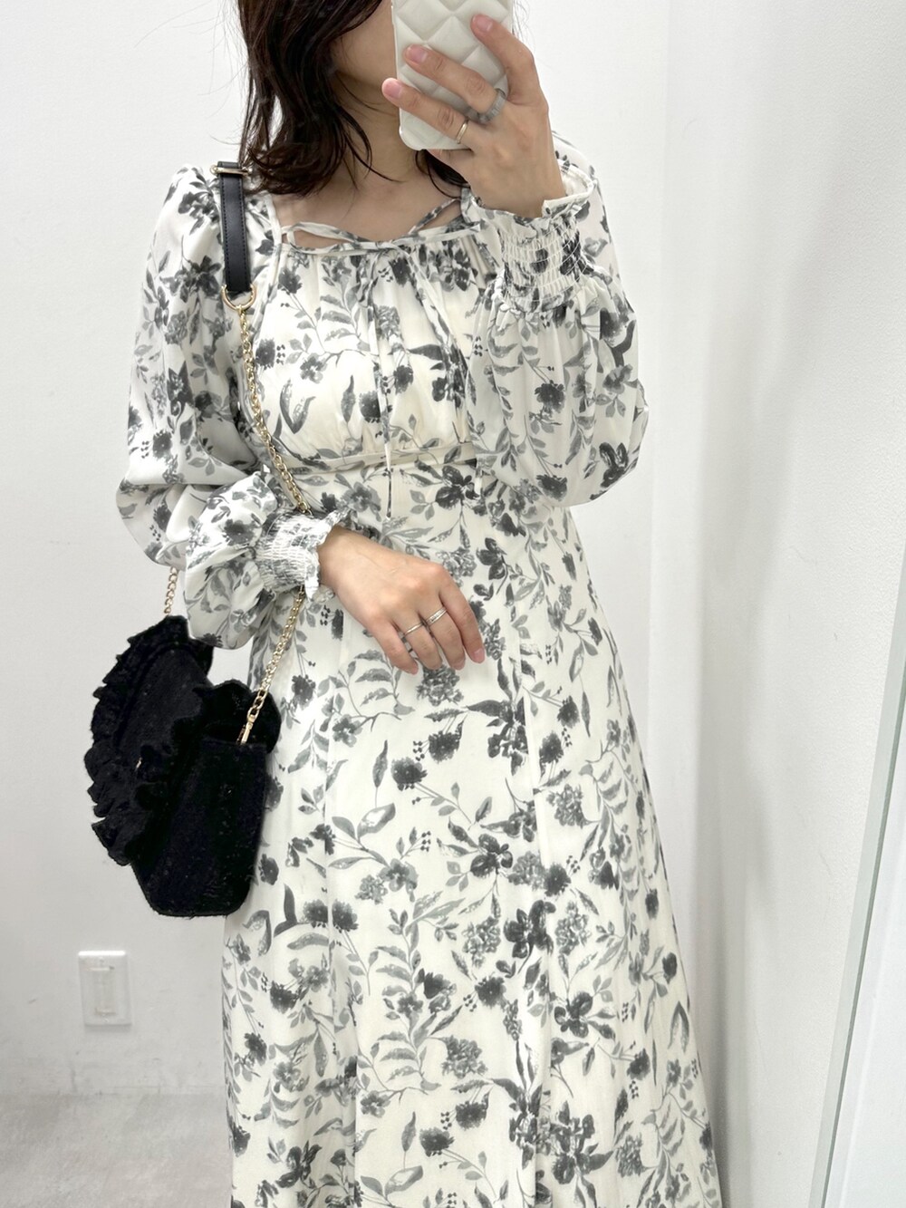 ブラック系のワンピース/ドレス、ブラック系のショルダーバッグ、ブラック系のブーツを着用したレディースの冬コーディネートの2枚目の写真