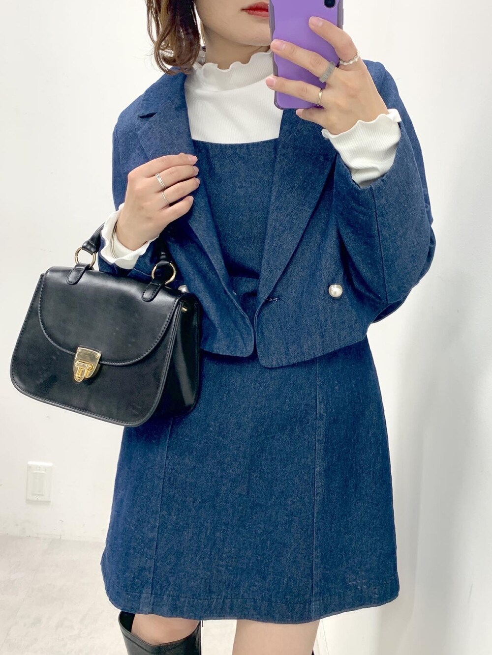 ブラック系のショルダーバッグ、ブラック系のブーツ、ブルー系のワンピースを着用したレディースの冬コーディネートの2枚目の写真