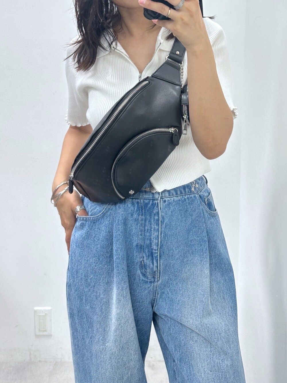 ブルー系のデニムパンツ、ブラック系のボディバッグ/ウエストポーチ、ホワイト系のTシャツ/カットソーを着用したレディースの夏コーディネートの2枚目の写真