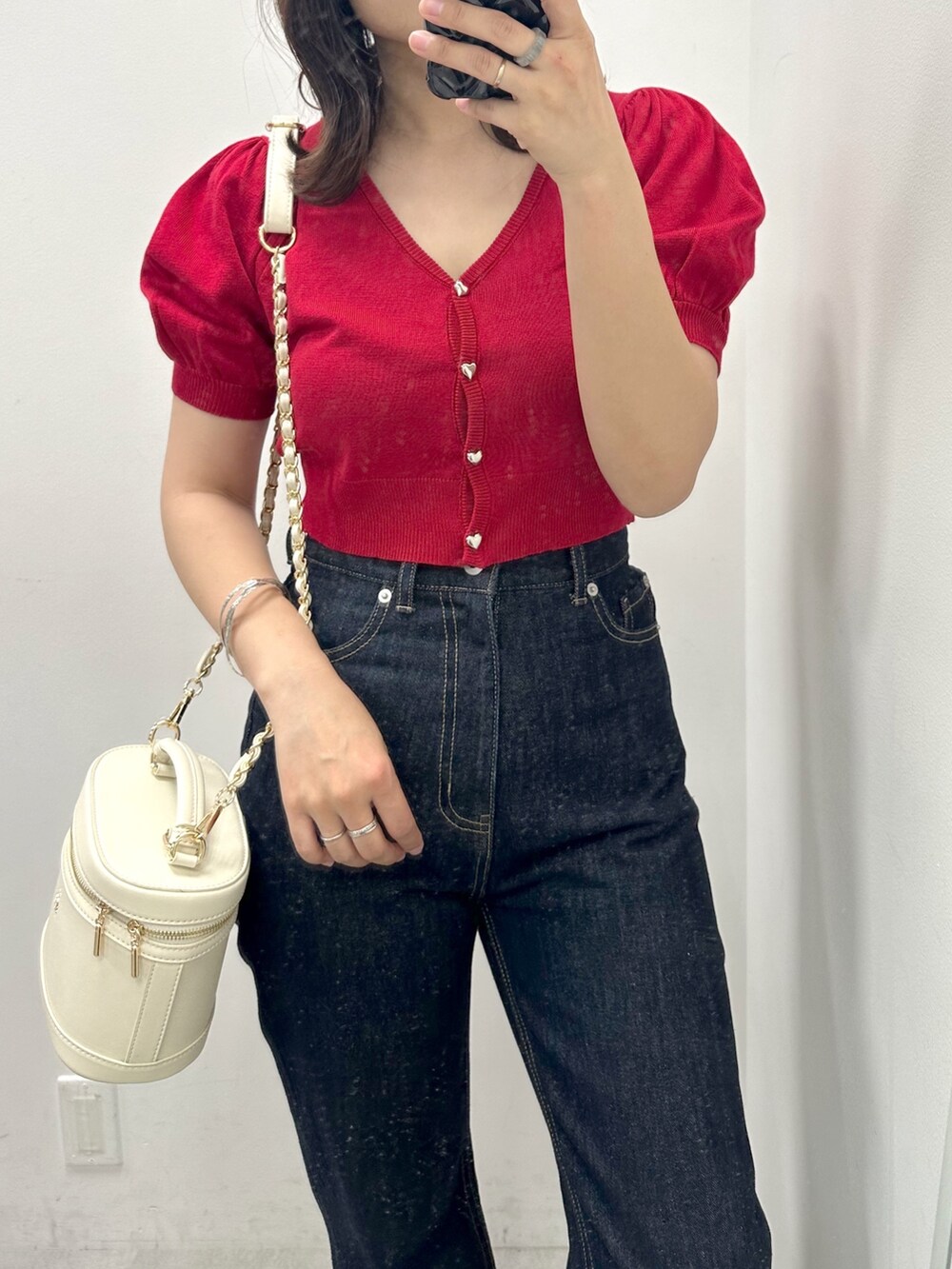 ブルー系のデニムパンツ、レッド系のカーディガン/ボレロ、ホワイト系のショルダーバッグを着用したレディースの夏コーディネートの2枚目の写真