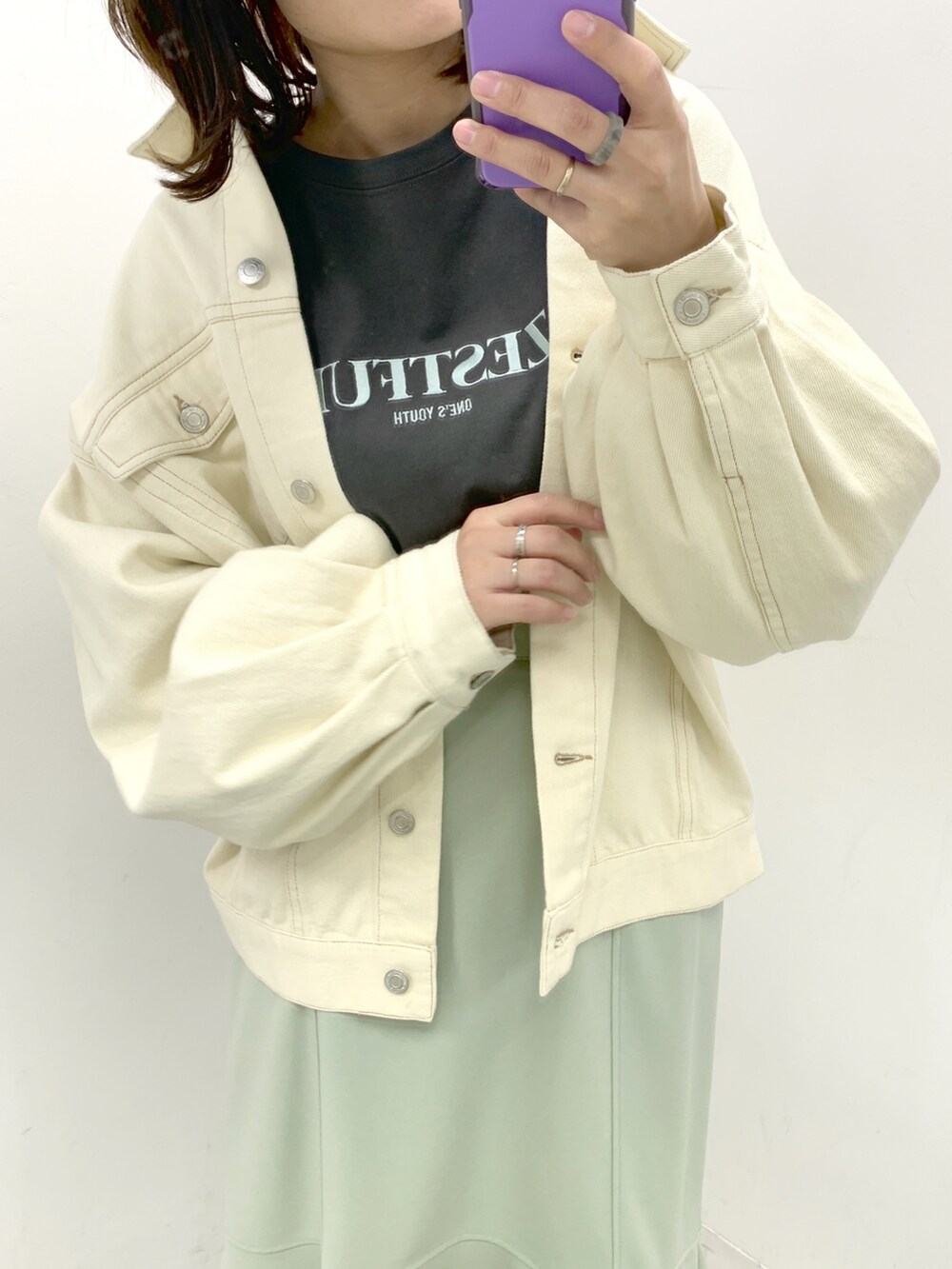 ホワイト系のブーツ、グリーン系のスカート、ホワイト系のデニムジャケットを着用したレディースの春コーディネートの2枚目の写真