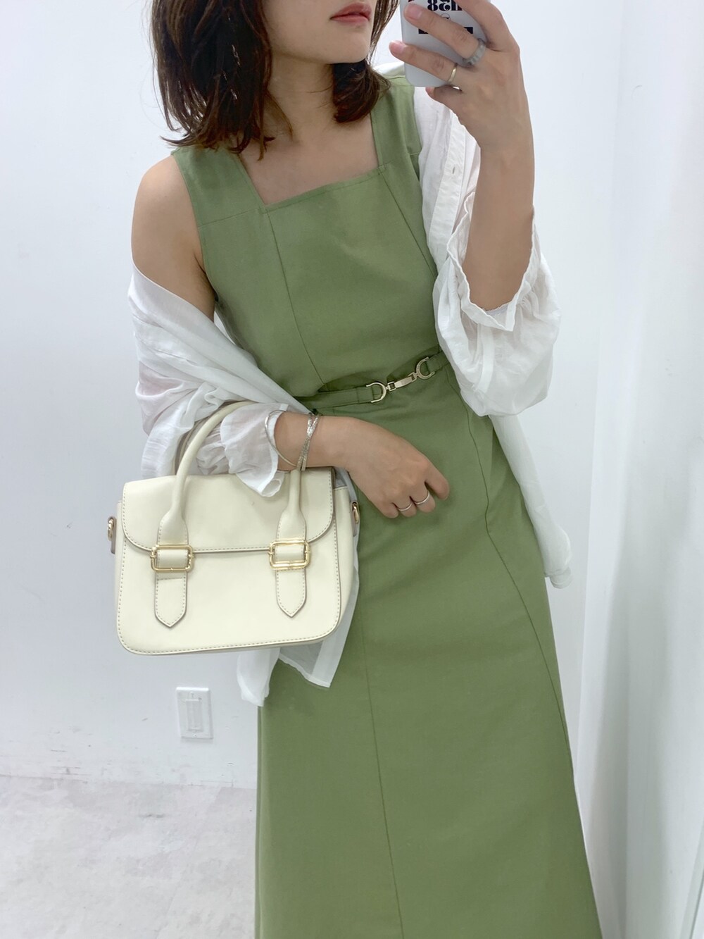 グリーン系のワンピース、ホワイト系のショルダーバッグ、ホワイト系のサンダルを着用したレディースの夏コーディネートの2枚目の写真