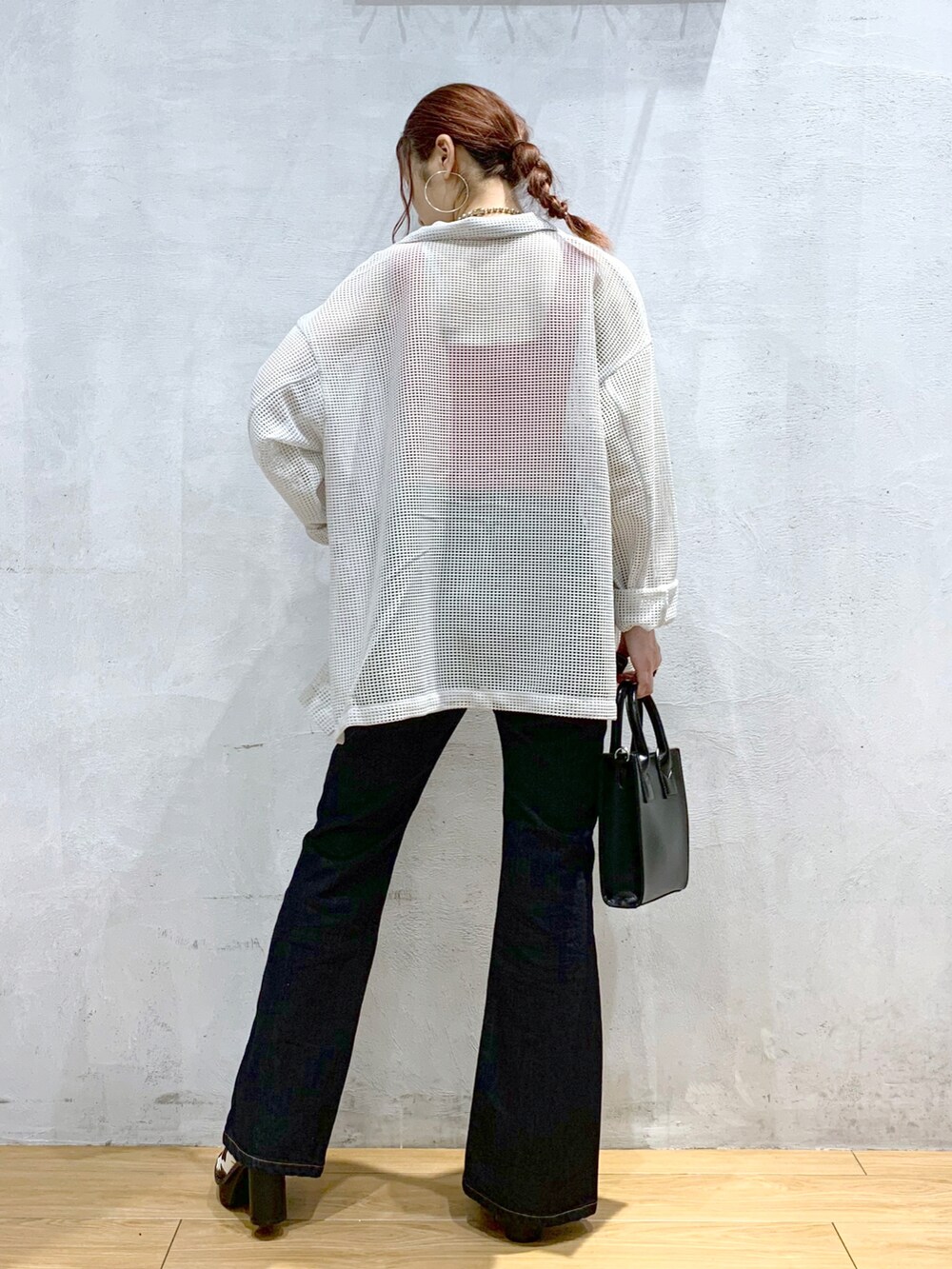 ブルー系のデニムパンツ、ホワイト系のサンダル、ブラック系のショルダーバッグを着用したレディースの春コーディネートの3枚目の写真