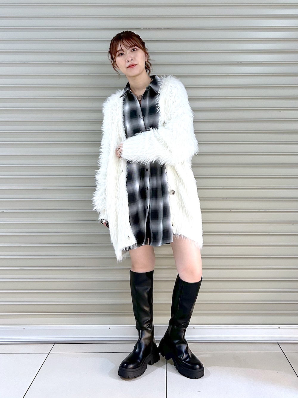 ブラック系のシャツ/ブラウス、ホワイト系のカーディガン/ボレロ、ブラック系のブーツを着用したレディースの秋コーディネートの2枚目の写真