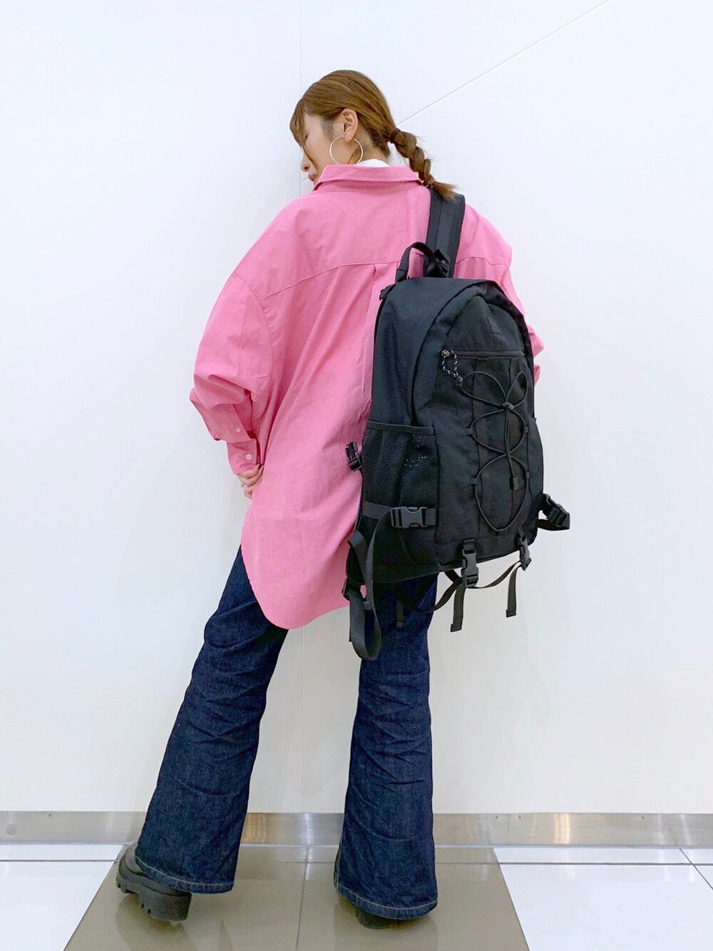 レッド系のシャツ/ブラウス、ホワイト系のニット/セーター、ブルー系のデニムパンツを着用したレディースの冬コーディネートの3枚目の写真