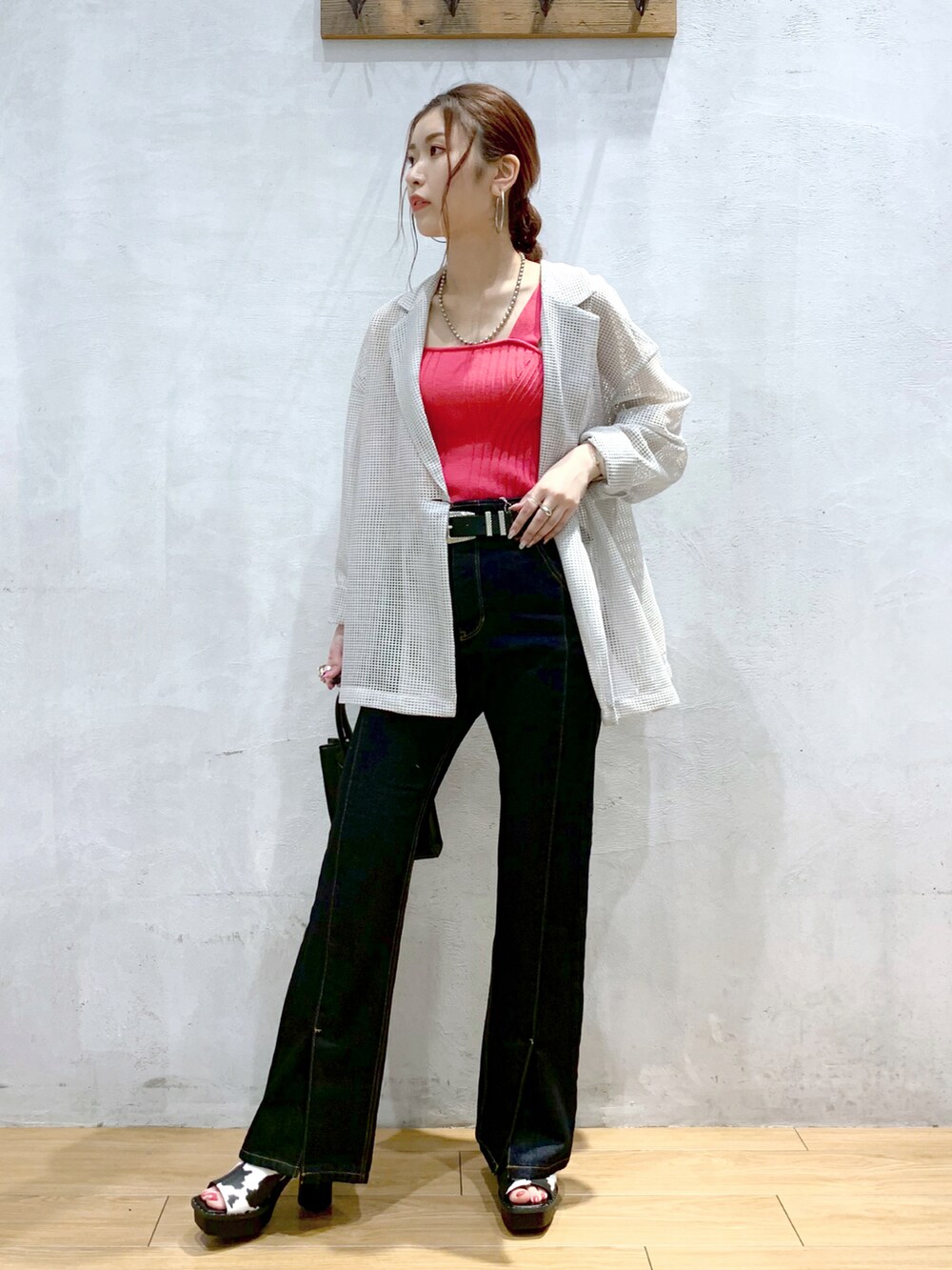 ブルー系のデニムパンツ、ホワイト系のサンダル、ブラック系のショルダーバッグを着用したレディースの春コーディネートの2枚目の写真