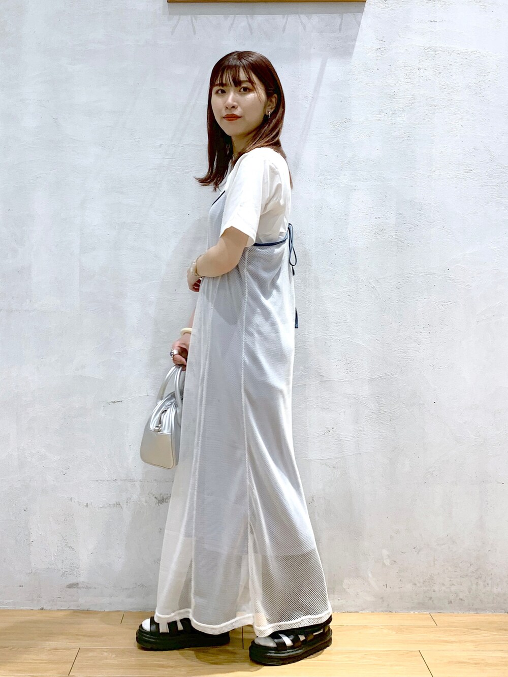シルバー系のショルダーバッグ、ホワイト系のワンピース、ホワイト系のTシャツ/カットソーを着用したレディースの夏コーディネートの3枚目の写真