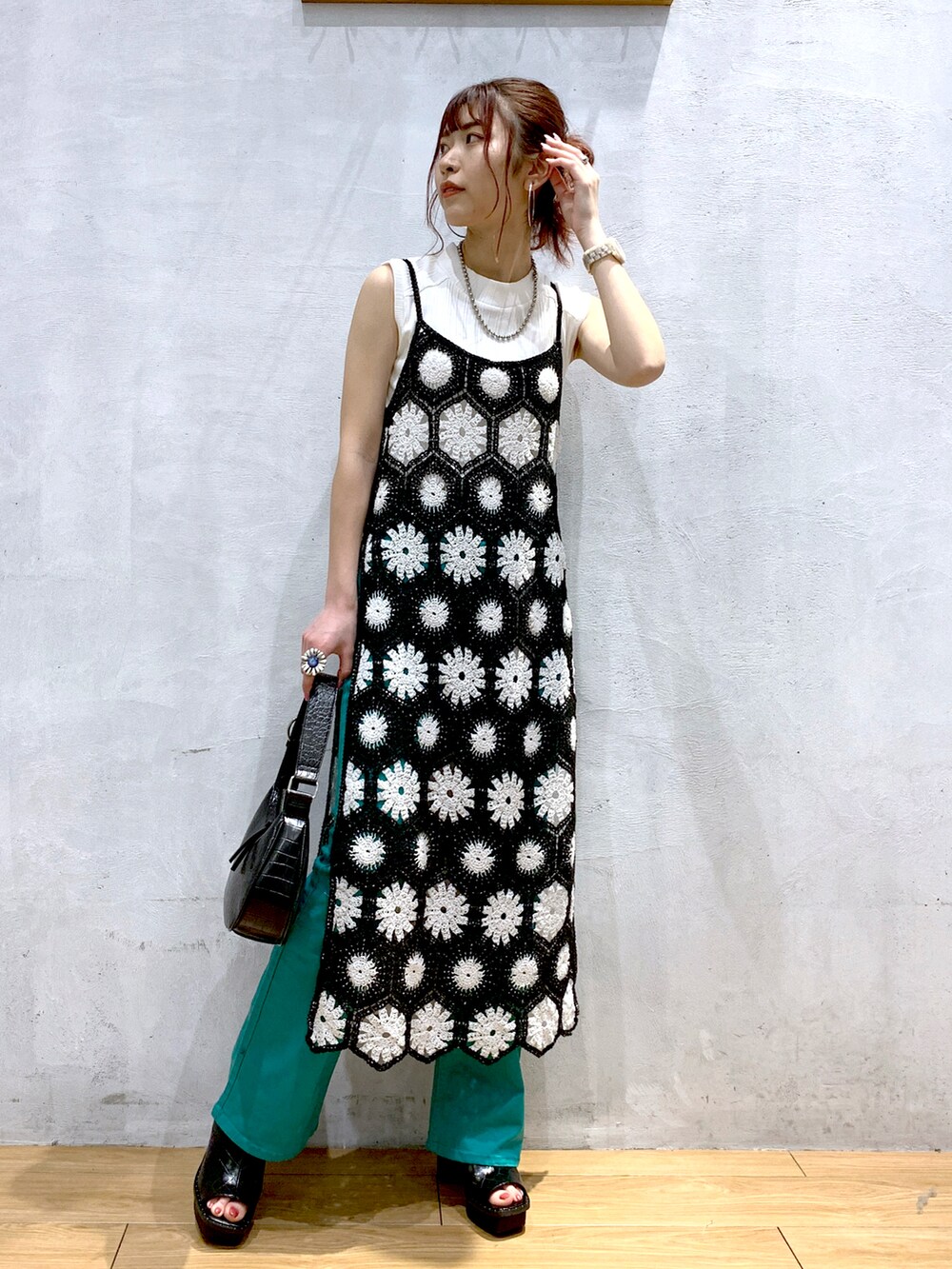 ブラック系のワンピース、ブラック系のショルダーバッグ、グリーン系のデニムパンツを着用したレディースの春コーディネートの2枚目の写真