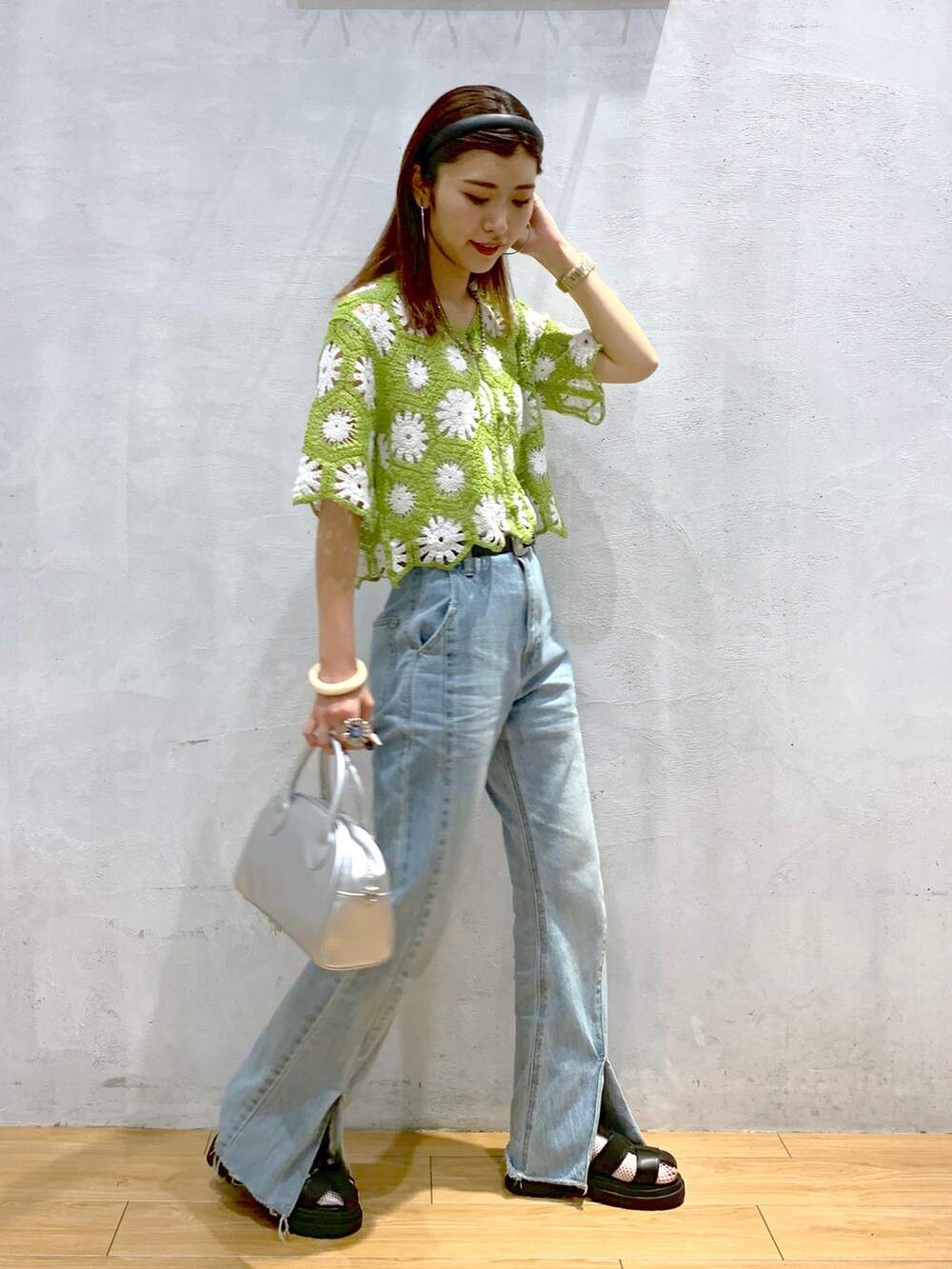 グリーン系のカーディガン/ボレロ、ブルー系のデニムパンツ、シルバー系のショルダーバッグを着用したレディースの夏コーディネートの2枚目の写真