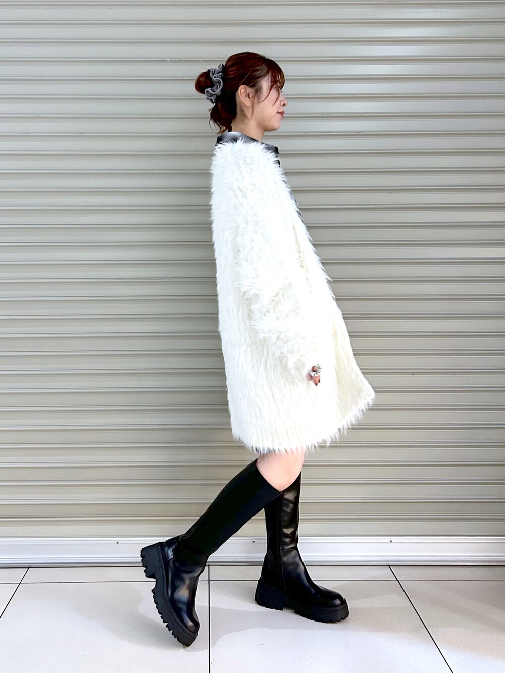 ブラック系のシャツ/ブラウス、ホワイト系のカーディガン/ボレロ、ブラック系のブーツを着用したレディースの秋コーディネートの3枚目の写真