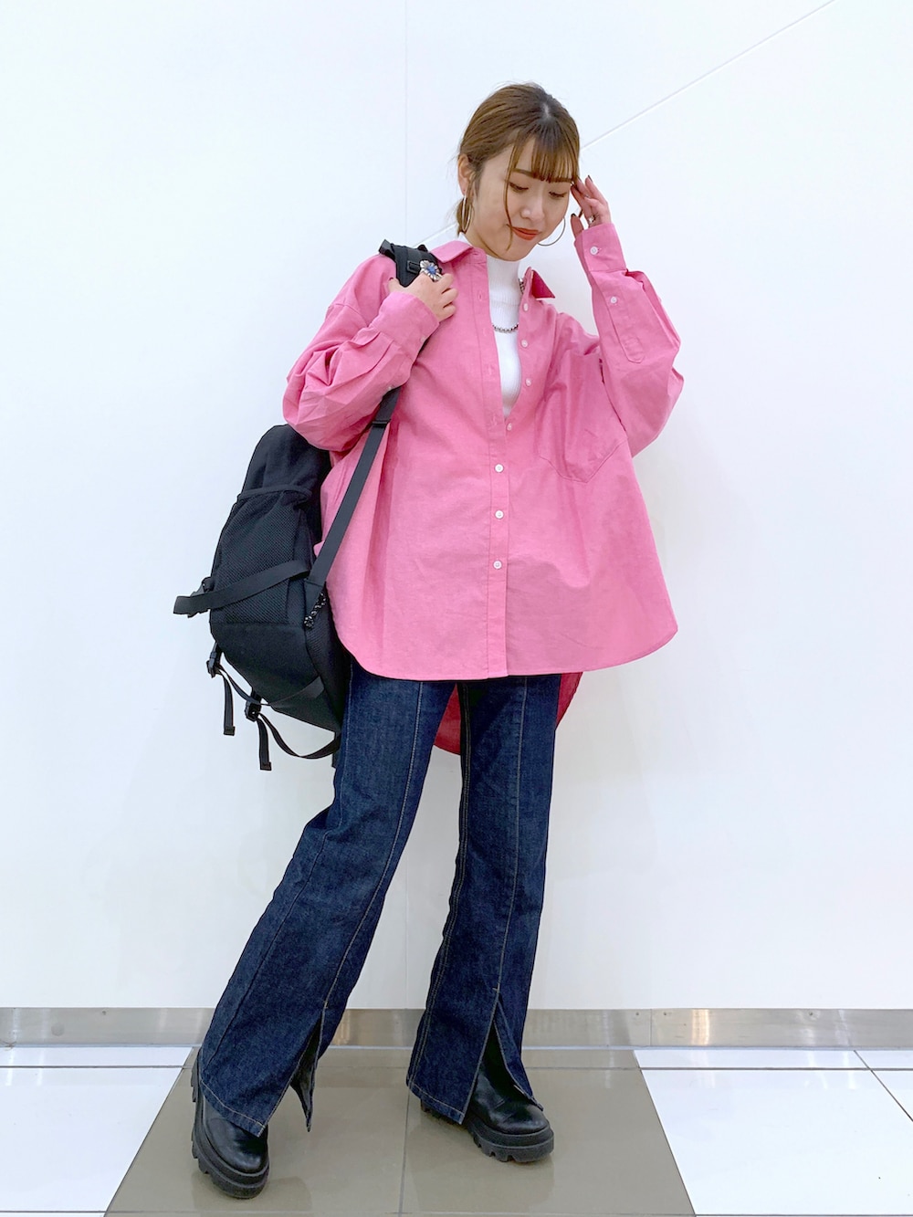 レッド系のシャツ/ブラウス、ホワイト系のニット/セーター、ブルー系のデニムパンツを着用したレディースの冬コーディネートの2枚目の写真