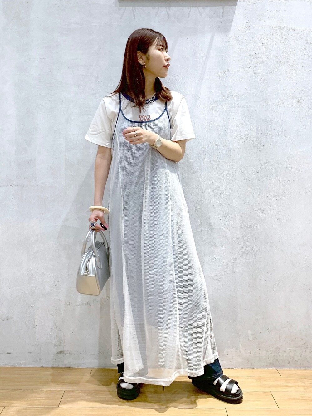 シルバー系のショルダーバッグ、ホワイト系のワンピース、ホワイト系のTシャツ/カットソーを着用したレディースの夏コーディネートの2枚目の写真