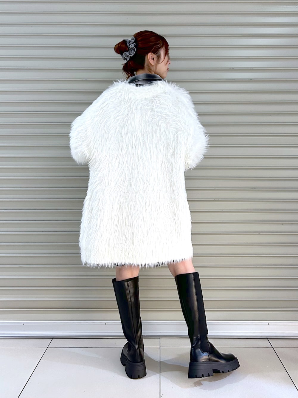 ブラック系のシャツ/ブラウス、ホワイト系のカーディガン/ボレロ、ブラック系のブーツを着用したレディースの秋コーディネートの4枚目の写真