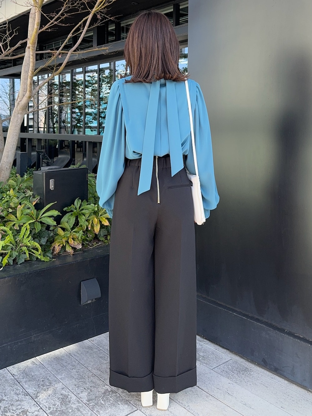 ブラック系のその他パンツ、ホワイト系のショルダーバッグを着用したレディースの冬コーディネートの3枚目の写真