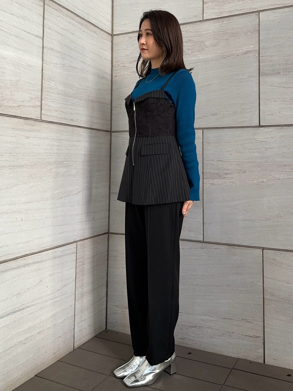 ブラック系のスラックス、ブルー系のニット/セーター、その他のシャツ/ブラウスを着用したレディースの冬コーディネートの4枚目の写真