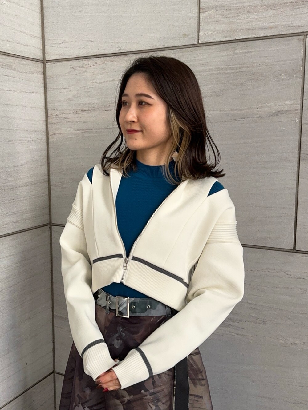 ブルー系のニット/セーター、ホワイト系のニット/セーター、グレー系のスカートを着用したレディースの冬コーディネートの4枚目の写真