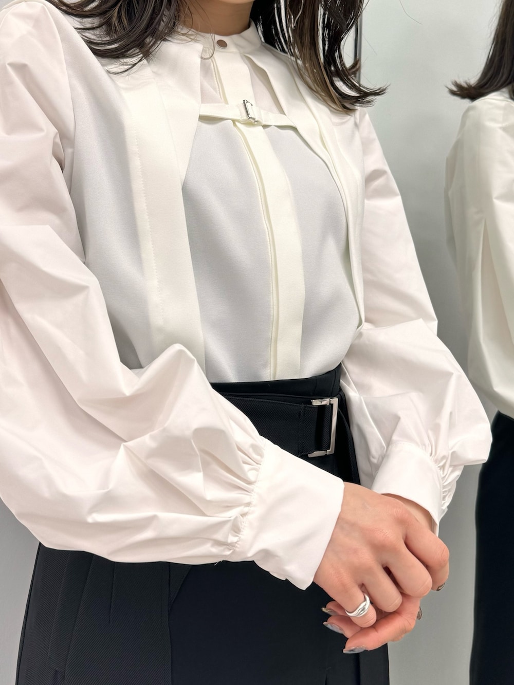 ホワイト系のシャツ/ブラウス、ブラック系のスカートを着用したレディースの冬コーディネートの7枚目の写真