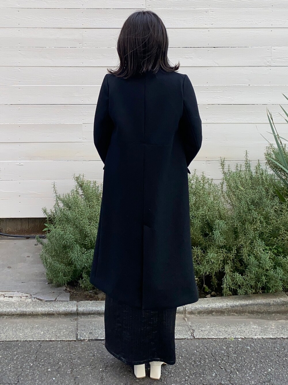 ブラック系のチェスターコートを着用したレディースの冬コーディネートの3枚目の写真