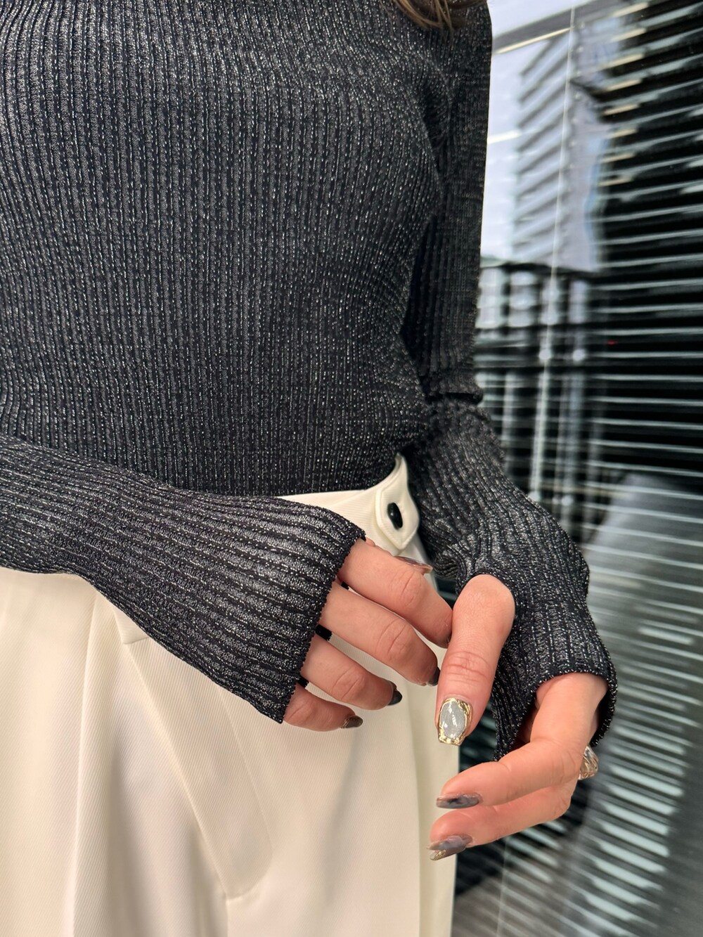 ブラック系のニット/セーター、ホワイト系のスラックスを着用したレディースの冬コーディネートの7枚目の写真