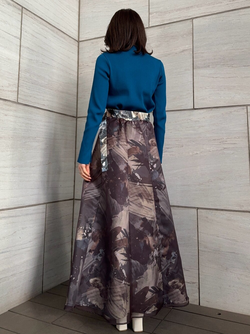 ブルー系のニット/セーター、グレー系のスカートを着用したレディースの冬コーディネートの3枚目の写真