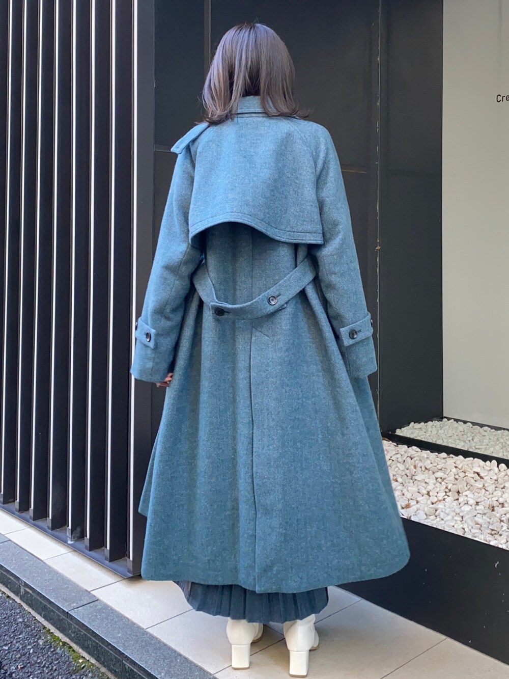 ブルー系のスカート、ブラック系のシャツ/ブラウス、その他のステンカラーコートを着用したレディースの冬コーディネートの4枚目の写真