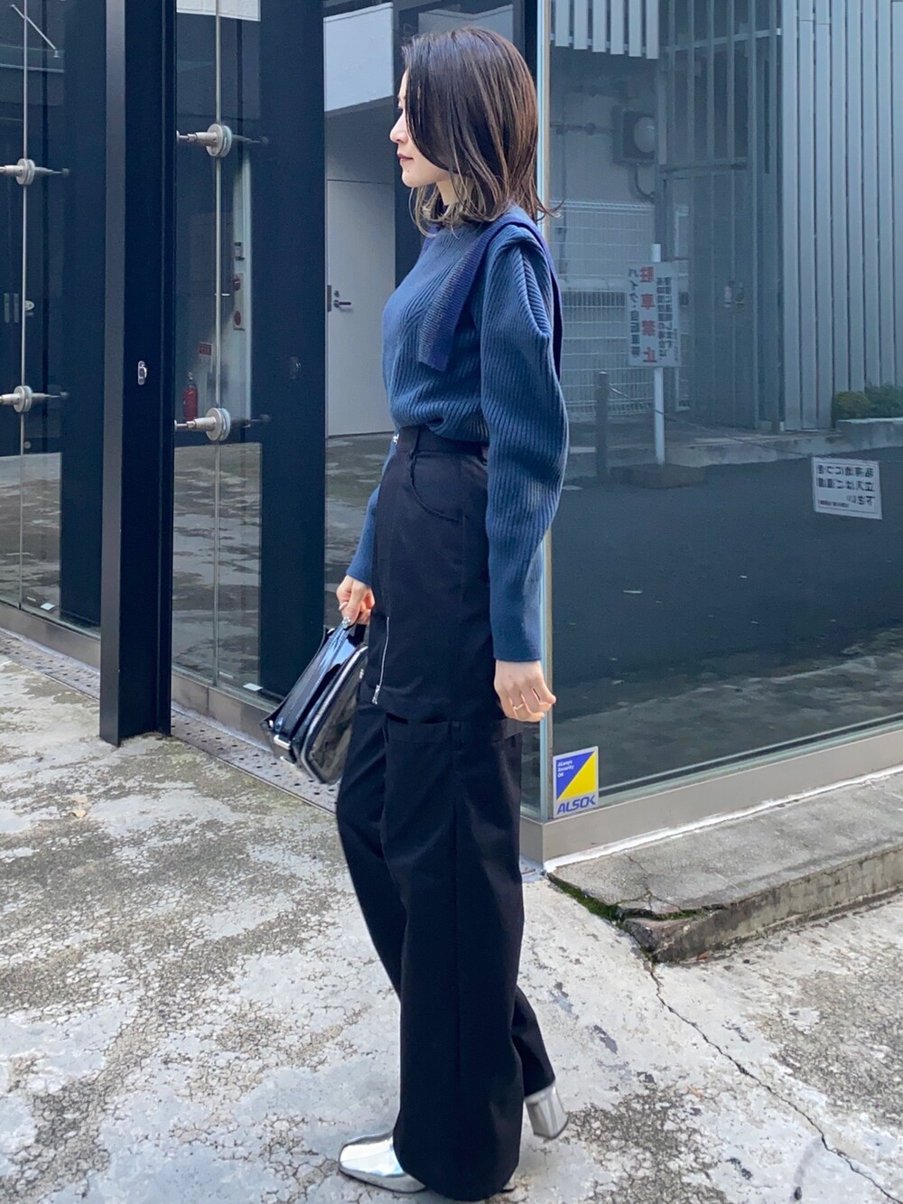 ブルー系のニット/セーター、ブラック系のその他パンツ、ブラック系のショルダーバッグを着用したレディースの冬コーディネートの4枚目の写真