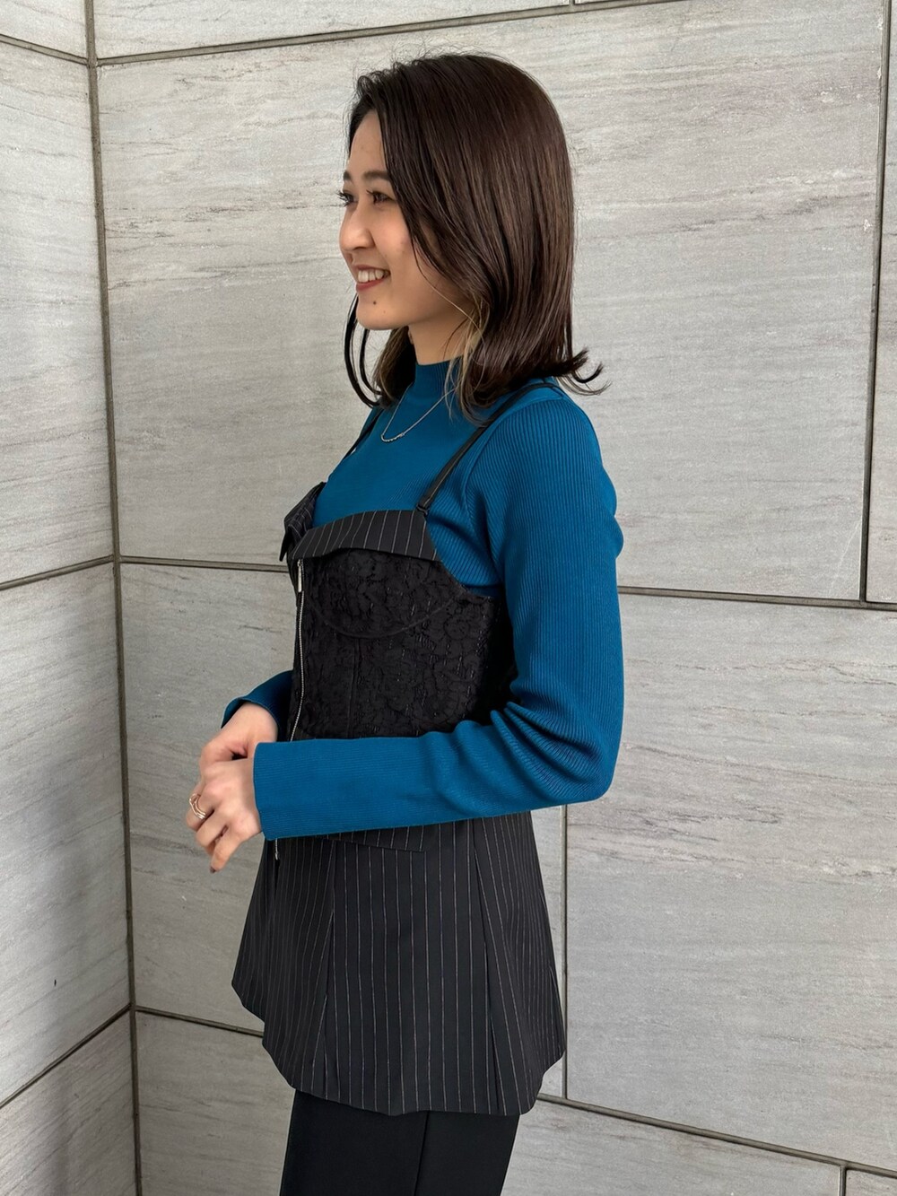 ブラック系のスラックス、ブルー系のニット/セーター、その他のシャツ/ブラウスを着用したレディースの冬コーディネートの7枚目の写真