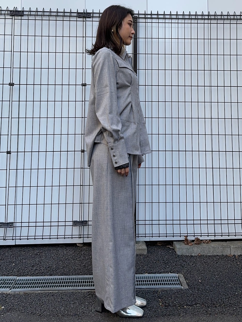 グレー系のシャツ/ブラウス、グレー系のスラックスを着用したレディースの冬コーディネートの2枚目の写真