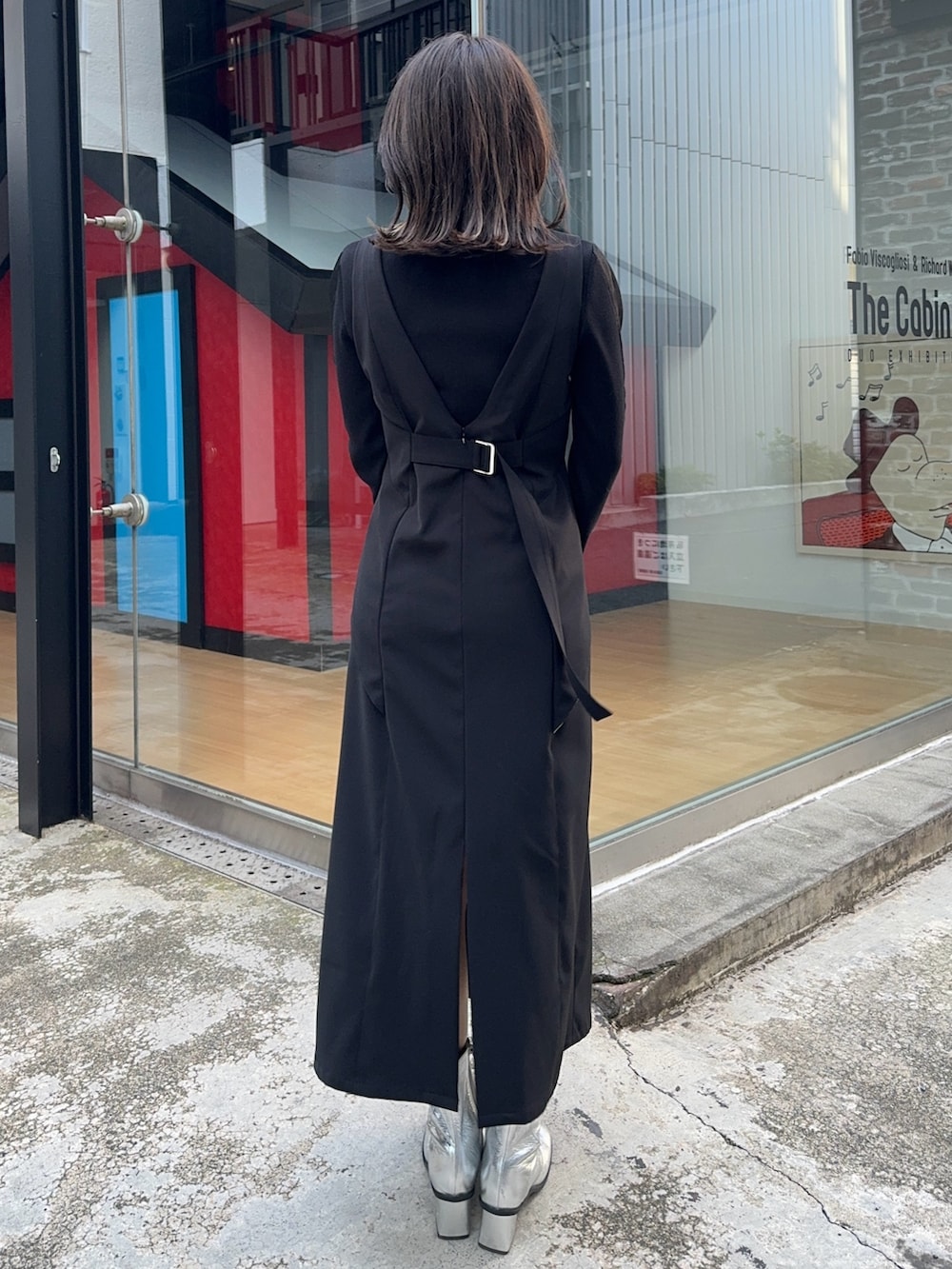 ブラック系のジャンパースカート、ブラック系のニット/セーター、シルバー系のショルダーバッグを着用したレディースの冬コーディネートの3枚目の写真