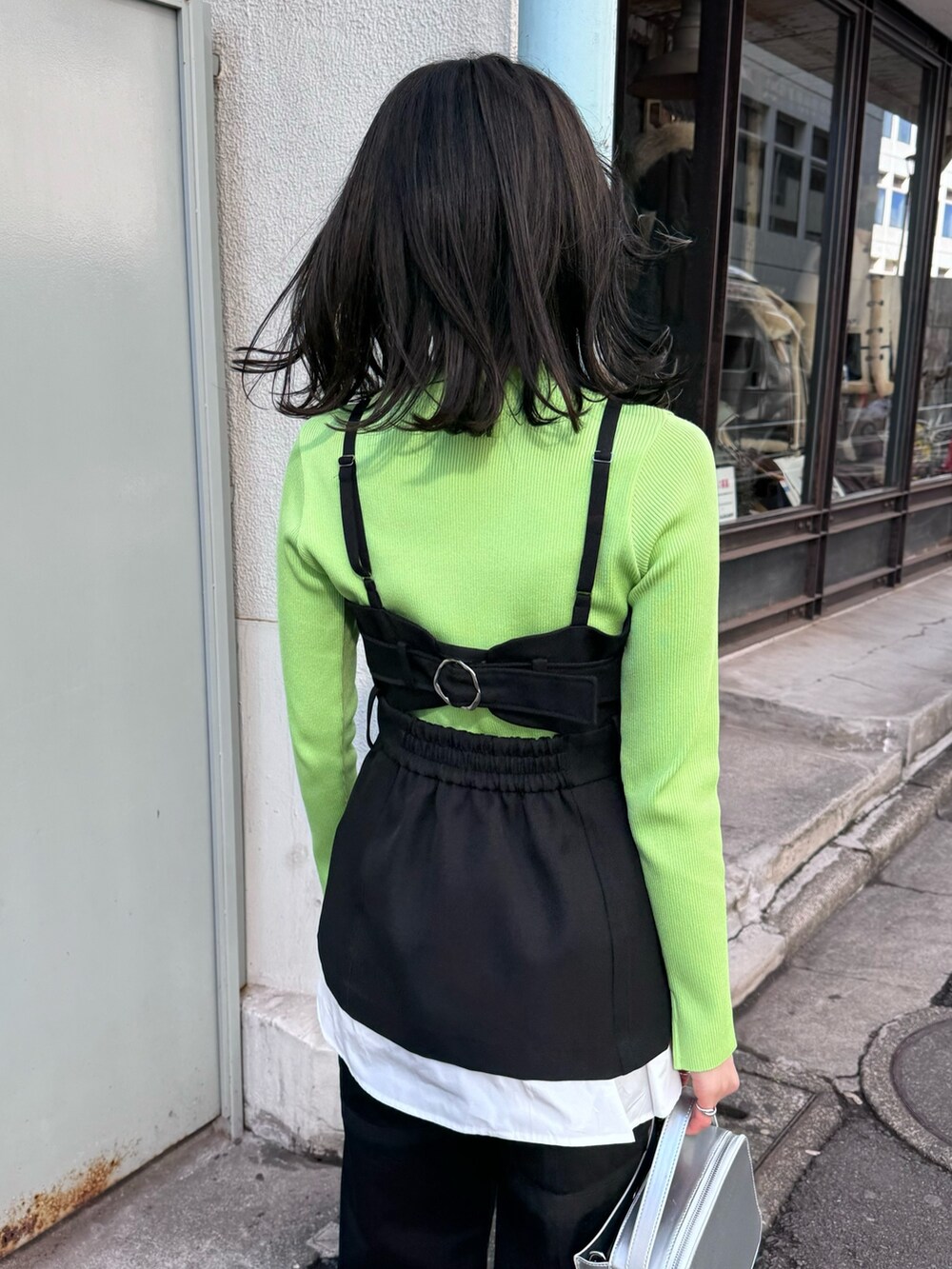 グリーン系のニット/セーター、ブラック系のベスト、ブラック系のその他パンツを着用したレディースの冬コーディネートの6枚目の写真