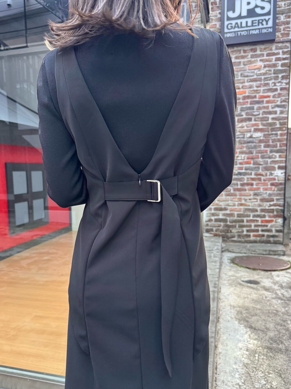 ブラック系のジャンパースカート、ブラック系のニット/セーター、シルバー系のショルダーバッグを着用したレディースの冬コーディネートの5枚目の写真