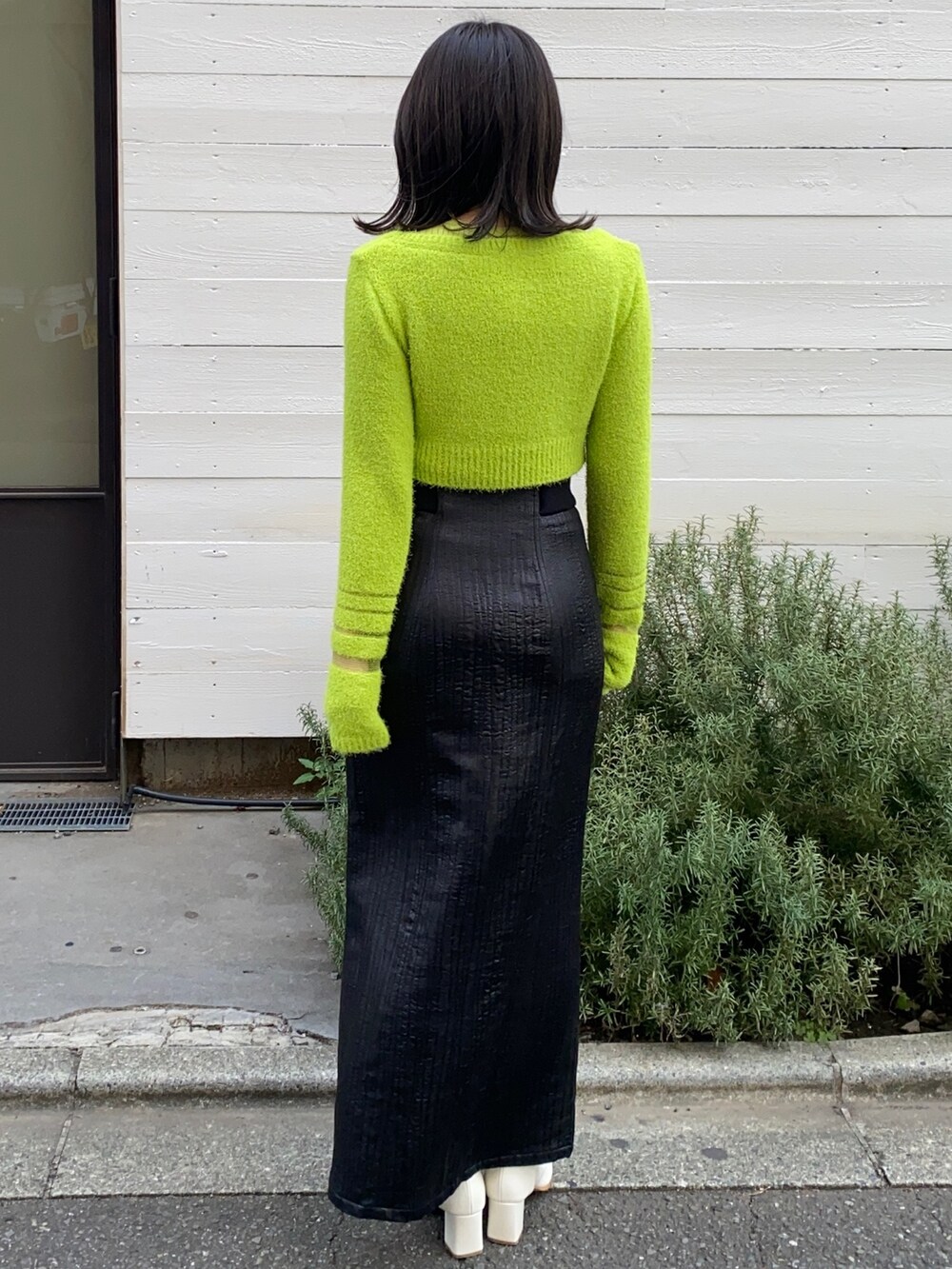 グリーン系のニット/セーター、ブラック系のスカートを着用したレディースの冬コーディネートの3枚目の写真