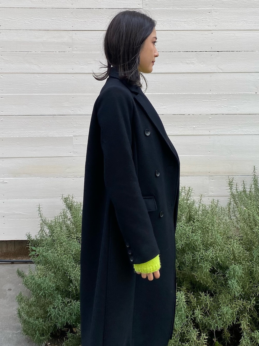 ブラック系のチェスターコートを着用したレディースの冬コーディネートの5枚目の写真