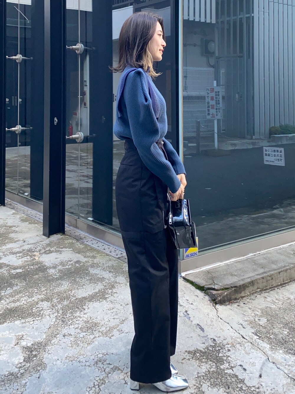 ブルー系のニット/セーター、ブラック系のその他パンツ、ブラック系のショルダーバッグを着用したレディースの冬コーディネートの2枚目の写真