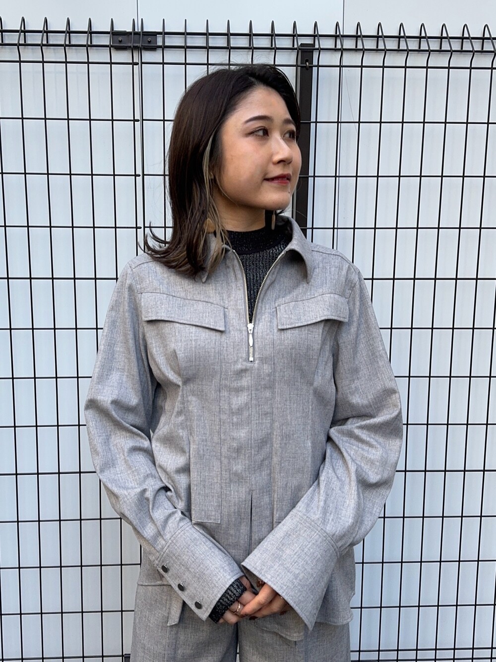 グレー系のシャツ/ブラウス、グレー系のスラックスを着用したレディースの冬コーディネートの5枚目の写真