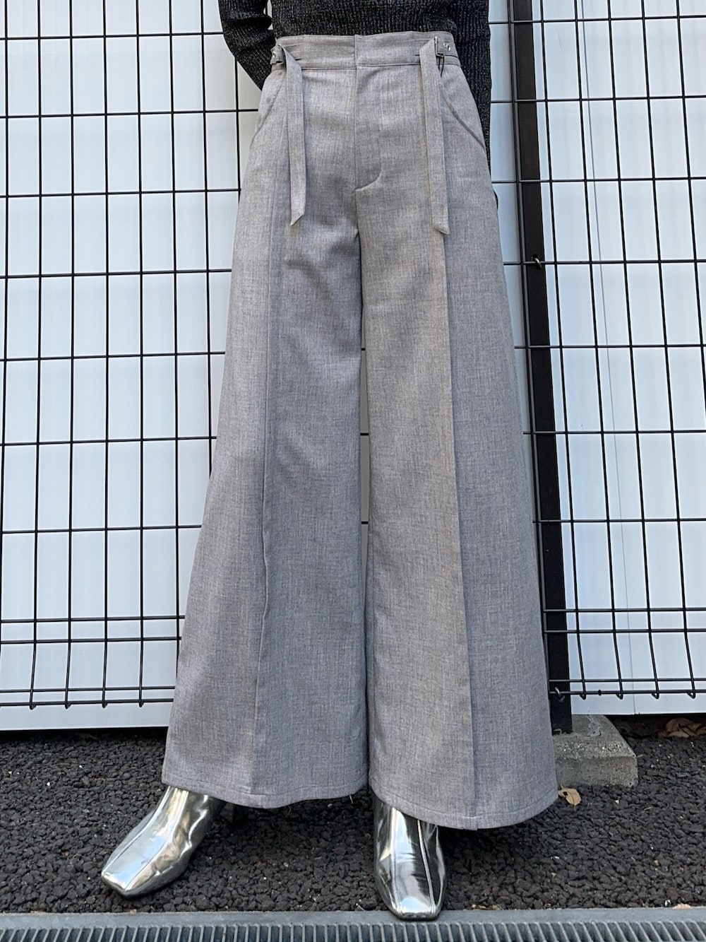 ブラック系のニット/セーター、グレー系のスラックスを着用したレディースの冬コーディネートの6枚目の写真