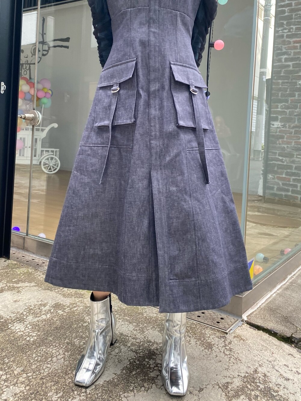 ブルー系のジャンパースカート、グリーン系のTシャツ/カットソー、シルバー系のショルダーバッグを着用したレディースの冬コーディネートの7枚目の写真