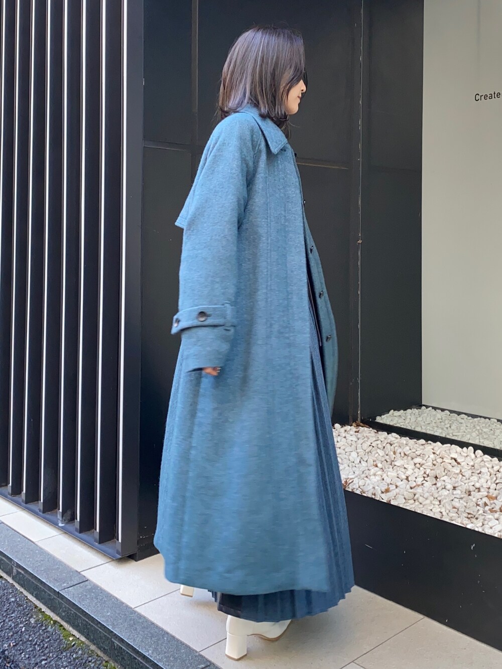 ブルー系のスカート、ブラック系のシャツ/ブラウス、その他のステンカラーコートを着用したレディースの冬コーディネートの3枚目の写真