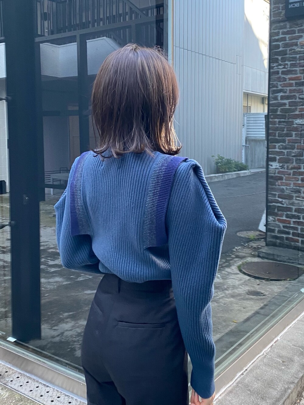 ブルー系のニット/セーター、ブラック系のその他パンツ、ブラック系のショルダーバッグを着用したレディースの冬コーディネートの6枚目の写真