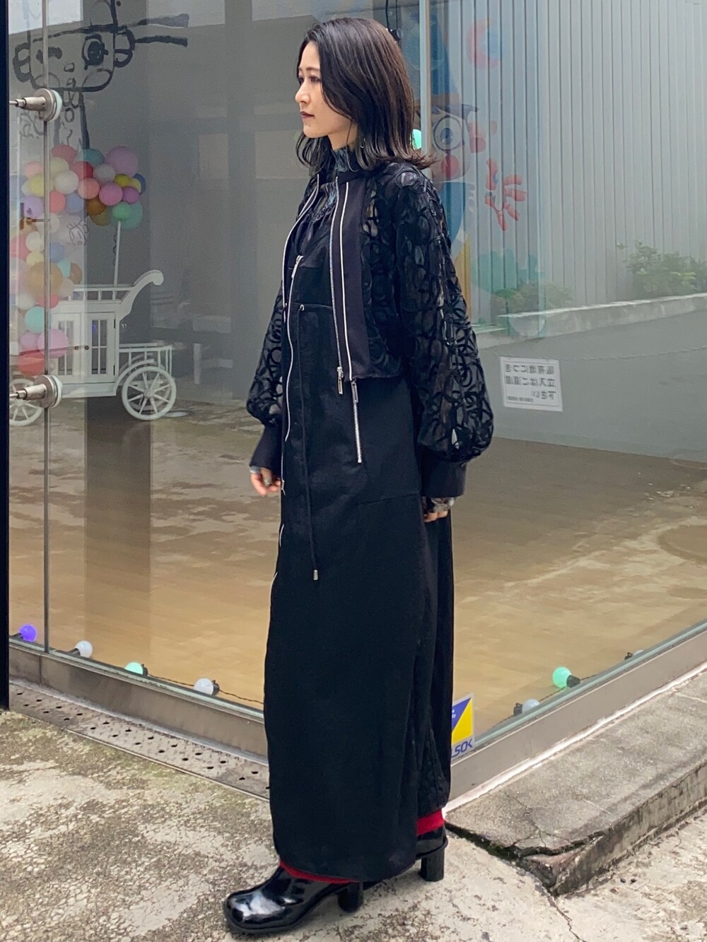 ブラック系のシャツ/ブラウス、ブラック系のジャンパースカート、レッド系のその他パンツを着用したレディースの冬コーディネートの4枚目の写真