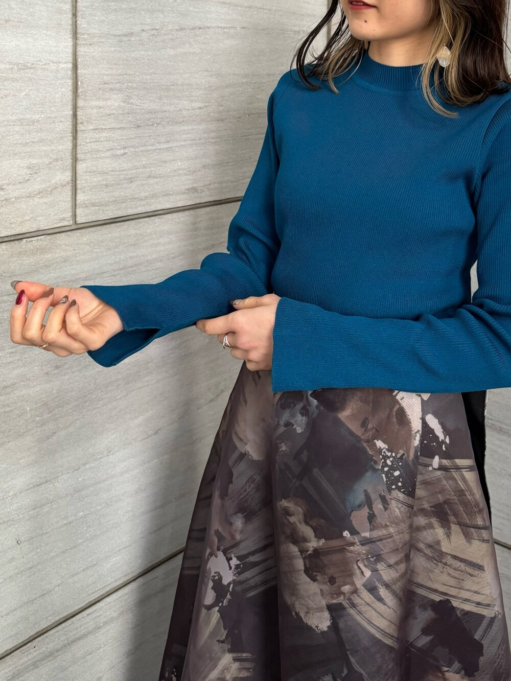 ブルー系のニット/セーター、グレー系のスカートを着用したレディースの冬コーディネートの7枚目の写真