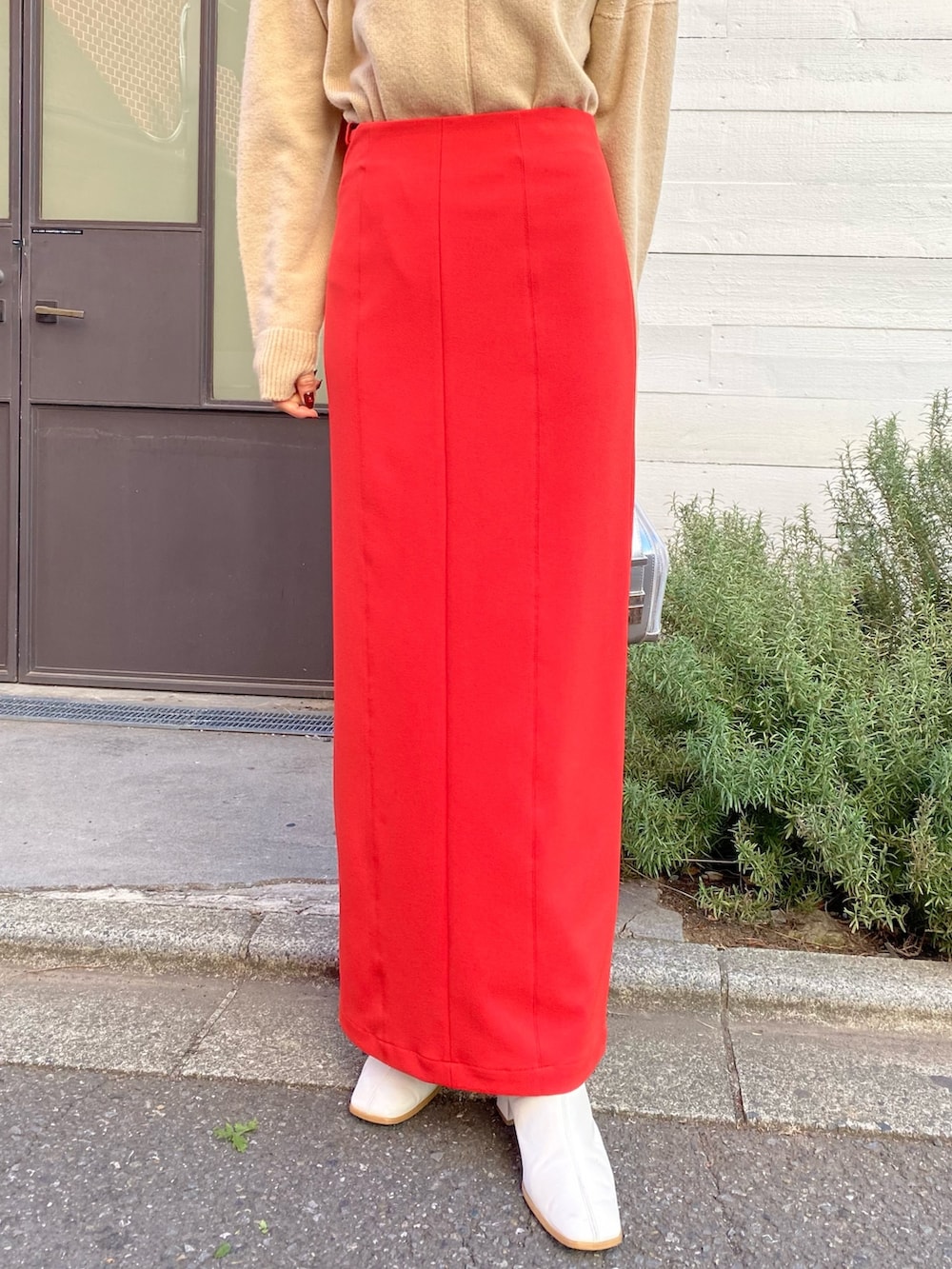 ベージュ系のニット/セーター、レッド系のスカート、シルバー系のショルダーバッグを着用したレディースの冬コーディネートの4枚目の写真