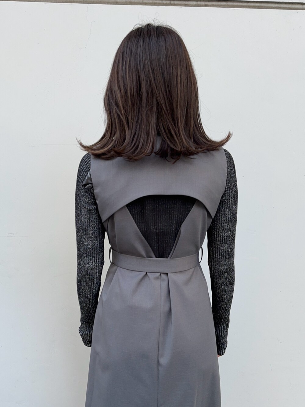 ブラック系のニット/セーター、グレー系のジャンパースカートを着用したレディースの冬コーディネートの7枚目の写真