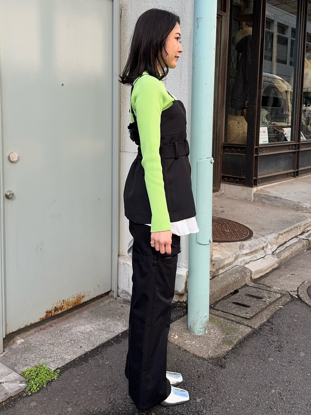 グリーン系のニット/セーター、ブラック系のベスト、ブラック系のその他パンツを着用したレディースの冬コーディネートの2枚目の写真