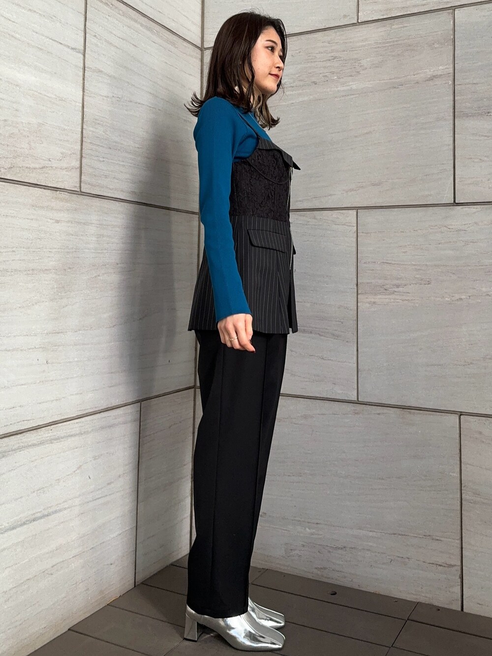 ブラック系のスラックス、ブルー系のニット/セーター、その他のシャツ/ブラウスを着用したレディースの冬コーディネートの2枚目の写真