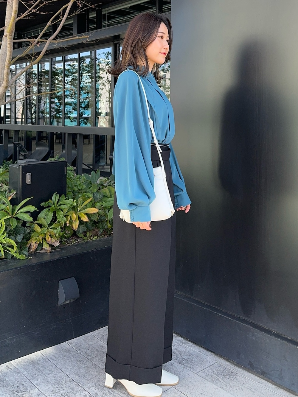 ブラック系のその他パンツ、ホワイト系のショルダーバッグを着用したレディースの冬コーディネートの2枚目の写真