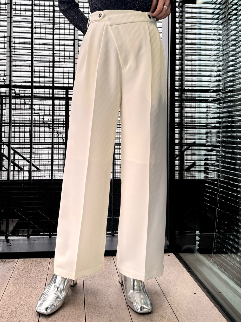 ブラック系のニット/セーター、ホワイト系のスラックスを着用したレディースの冬コーディネートの8枚目の写真