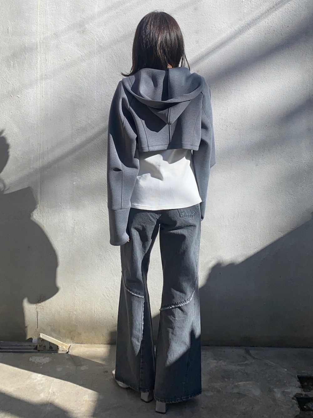 ホワイト系のTシャツ/カットソー、グレー系のパーカー、ブラック系のデニムパンツを着用したレディースの冬コーディネートの3枚目の写真