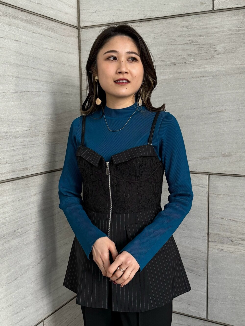 ブラック系のスラックス、ブルー系のニット/セーター、その他のシャツ/ブラウスを着用したレディースの冬コーディネートの5枚目の写真