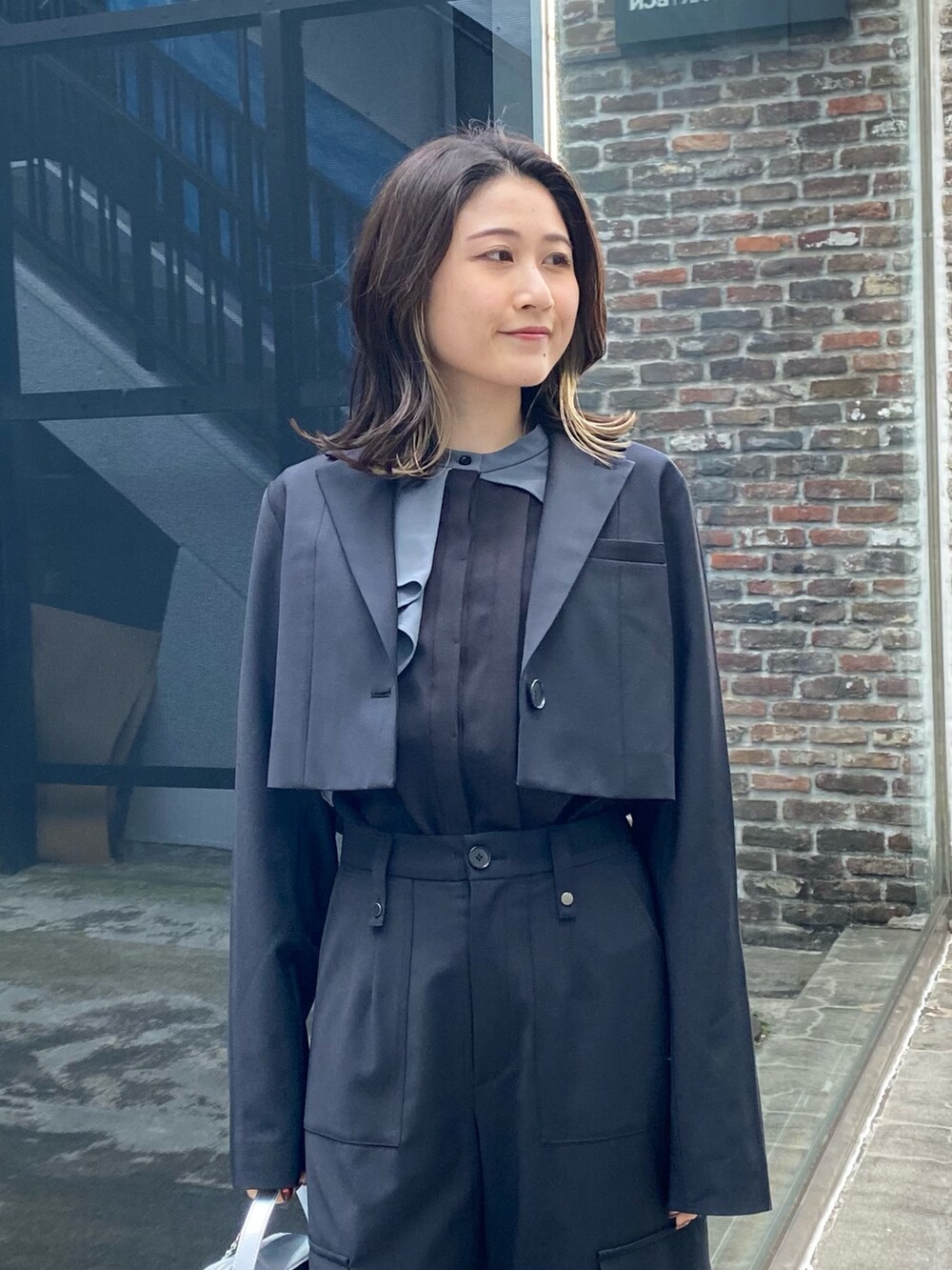 シルバー系のショルダーバッグ、ブラック系のシャツ/ブラウス、ブラック系のテーラードジャケットを着用したレディースの冬コーディネートの5枚目の写真